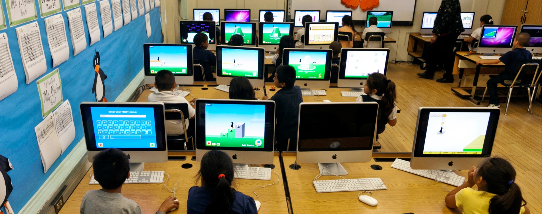 Students engaging with interactive smart boards and digital devices in a modern classroom setting